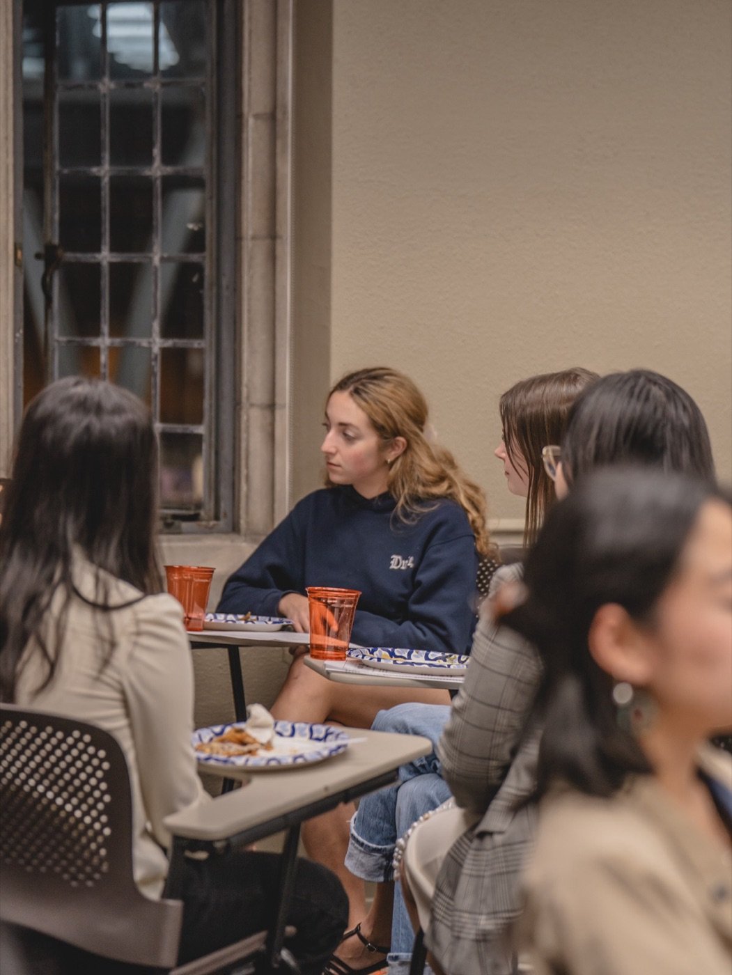 Students listening around their desks, with food and drinks